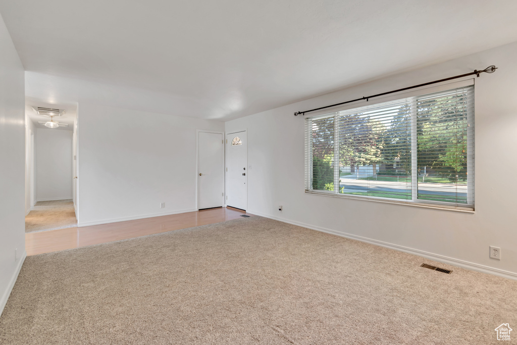 Spare room featuring carpet and baseboards