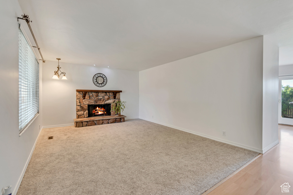 Unfurnished living room featuring baseboards, a fireplace, wood finished floors, and carpet flooring