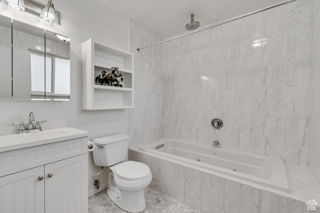 Bathroom with a combined bath / shower with rainfall shower, toilet, and vanity