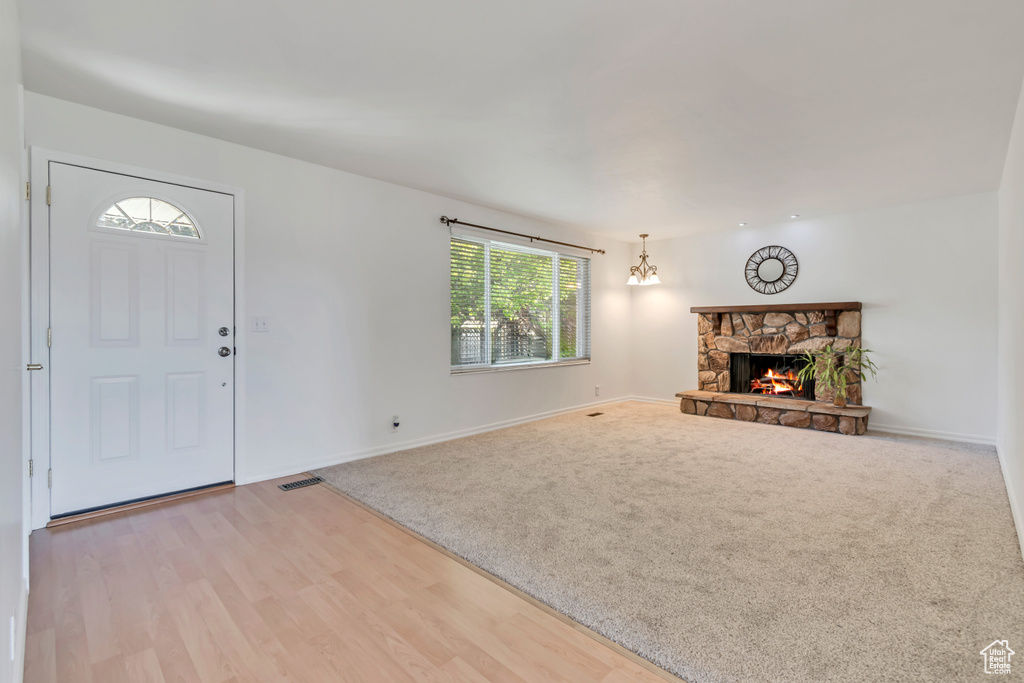 Unfurnished living room featuring a fireplace, baseboards, wood finished floors, and carpet floors