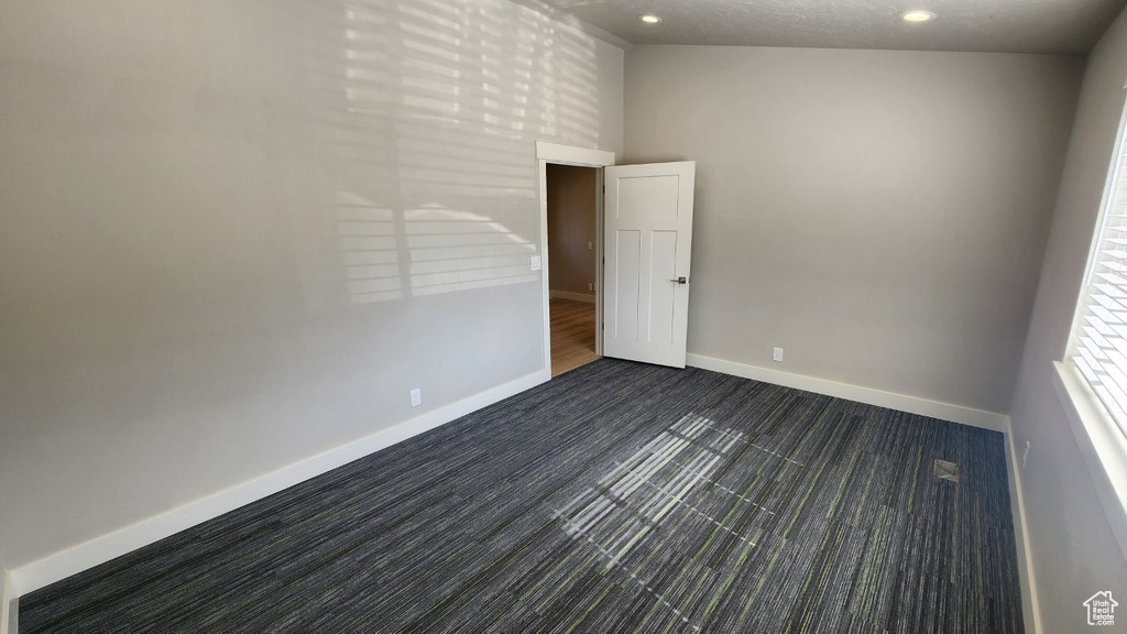 Unfurnished room featuring recessed lighting, baseboards, and dark carpet