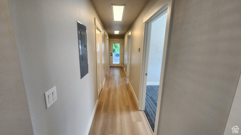 Hallway with light wood-type flooring and baseboards