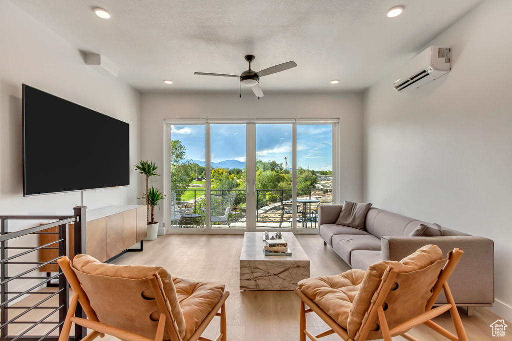 Living room with an AC wall unit, a ceiling fan, light wood-style floors, recessed lighting, and a mountain view