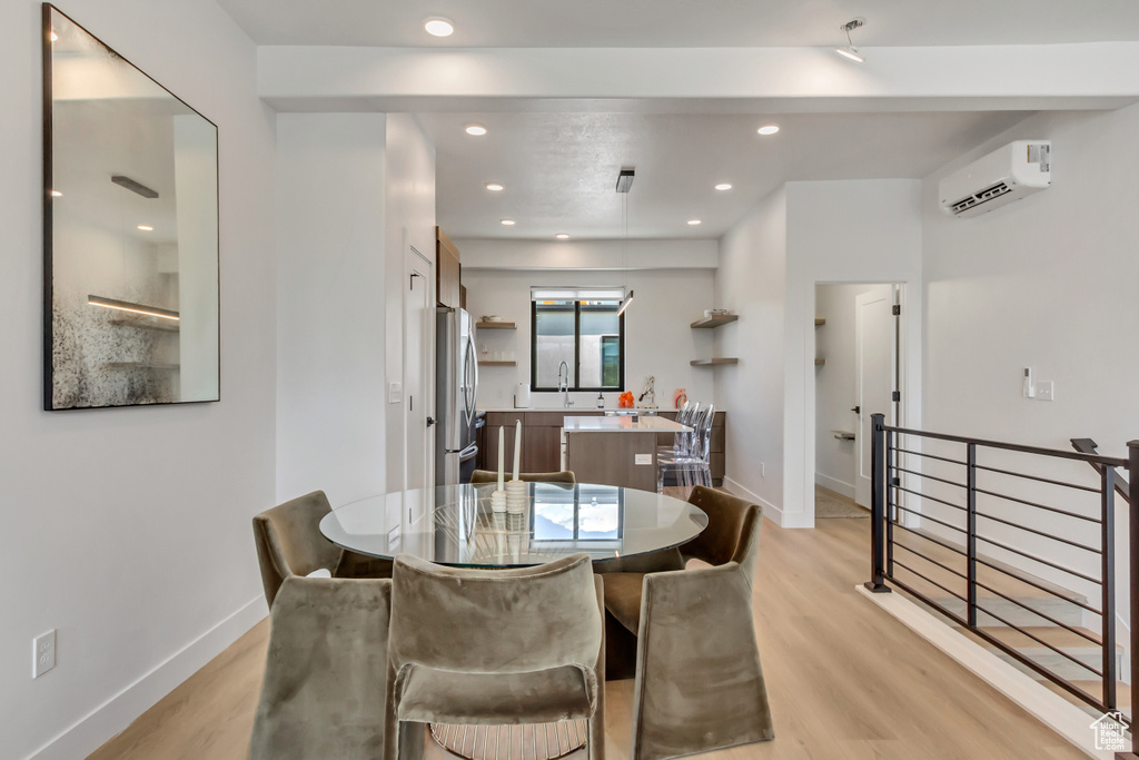 Dining area featuring a wall mounted AC, light wood-type flooring, recessed lighting, and baseboards