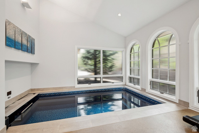 View of swimming pool with a hot tub