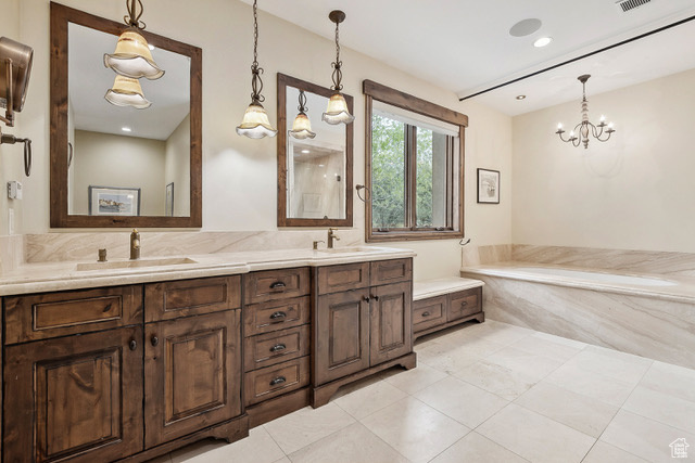 Full bath with double vanity, a bath, tile patterned floors, a chandelier, and recessed lighting