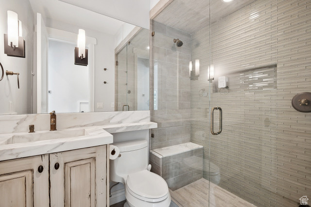 Bathroom with toilet, vanity, and a shower stall
