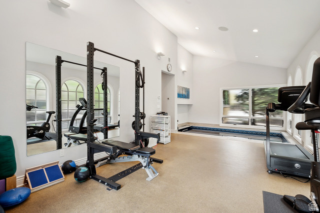 Gym with lofted ceiling and recessed lighting