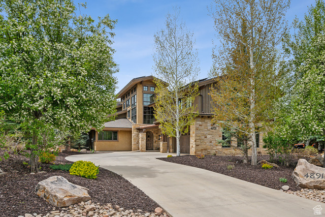 View of front of property with stone siding, concrete driveway, and an attached garage