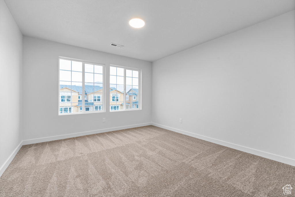 Carpeted spare room with baseboards
