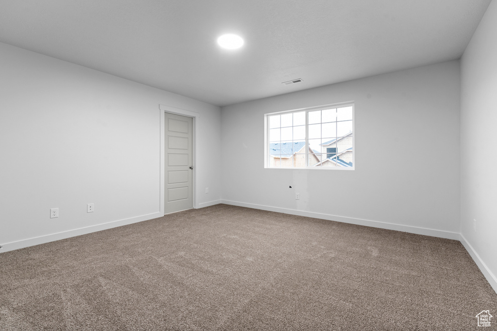Empty room featuring carpet floors and baseboards