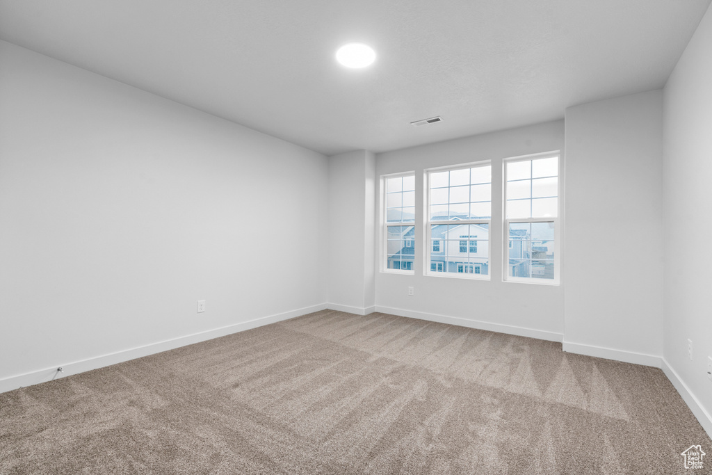Spare room featuring carpet floors and baseboards
