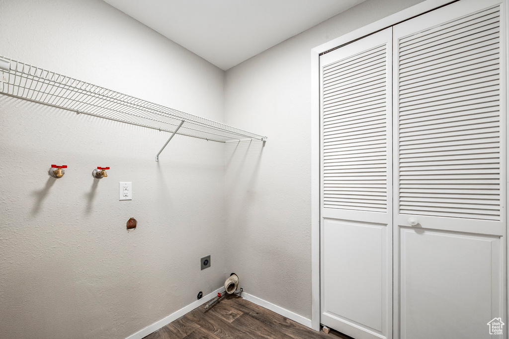 Washroom featuring hookup for a gas dryer, hookup for an electric dryer, baseboards, and dark wood finished floors