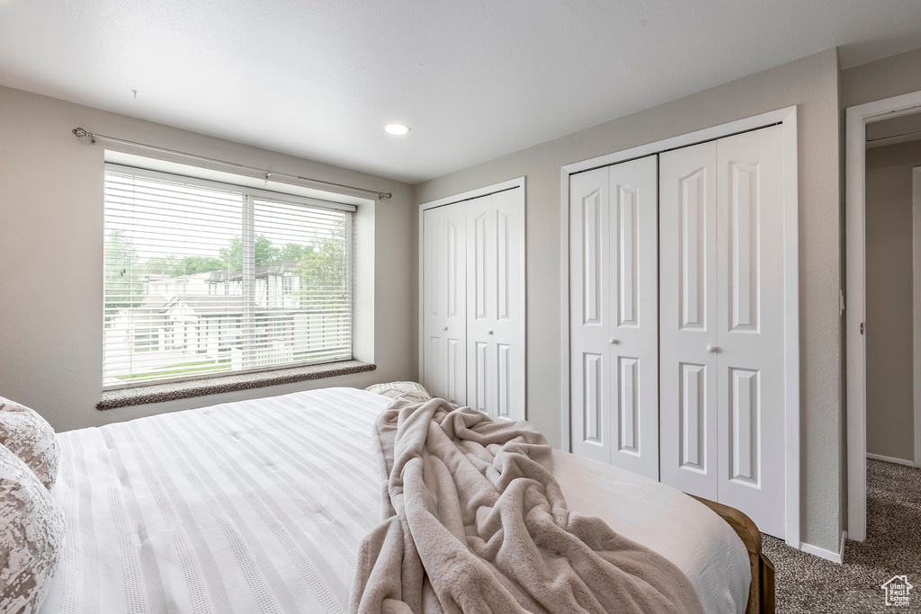 Carpeted bedroom with two closets and recessed lighting