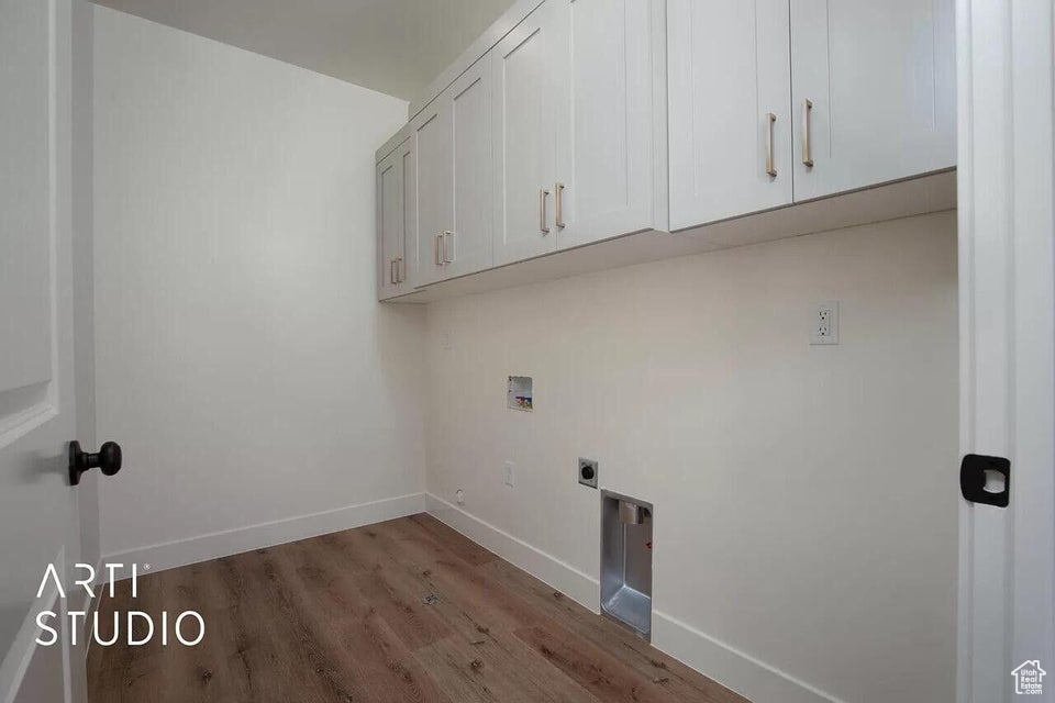 Laundry room featuring cabinet space, washer hookup, wood finished floors, baseboards, and hookup for an electric dryer
