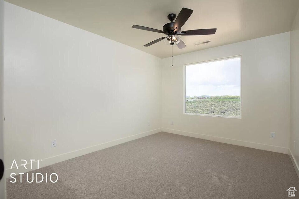 Empty room with baseboards, carpet floors, and ceiling fan