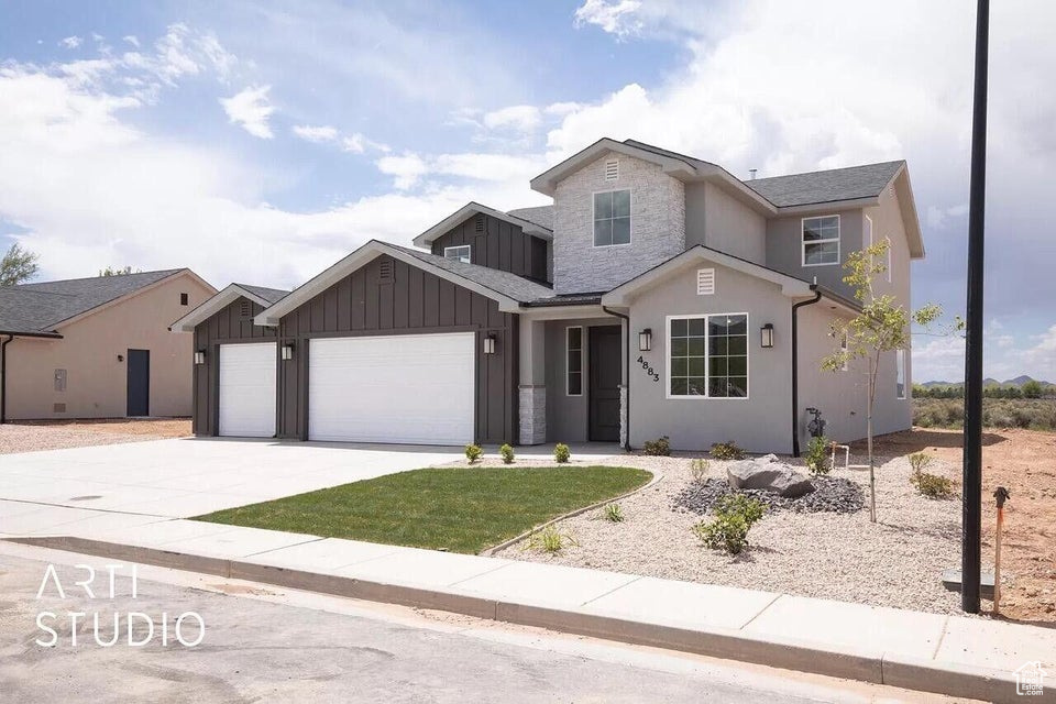 View of front of home featuring board and batten siding, a garage, and concrete driveway