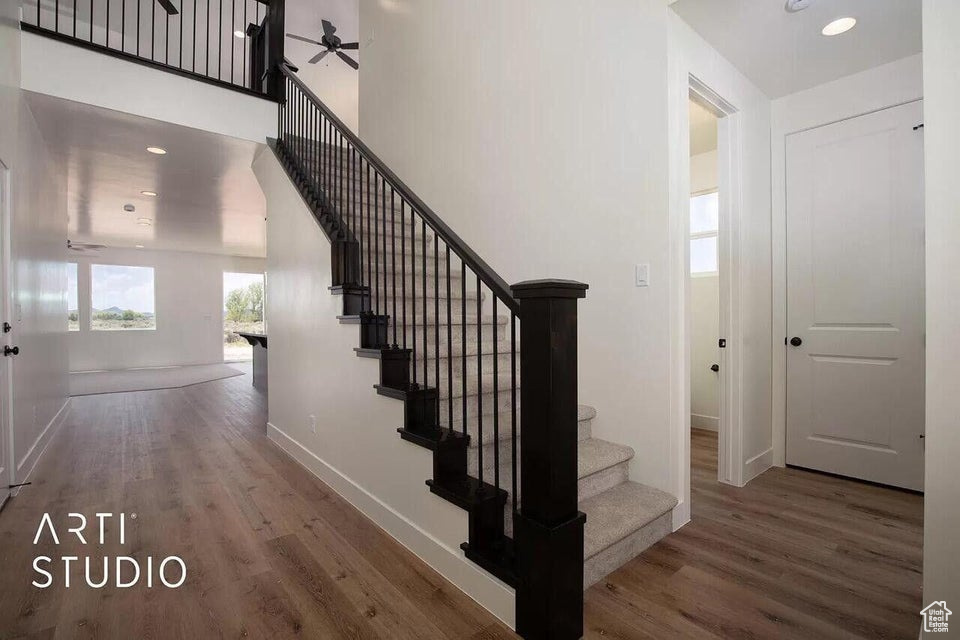 Stairway with wood finished floors, baseboards, a ceiling fan, and recessed lighting