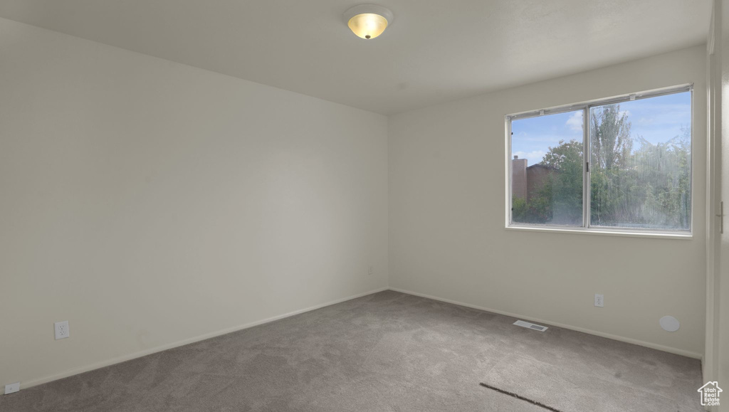 Carpeted spare room with baseboards