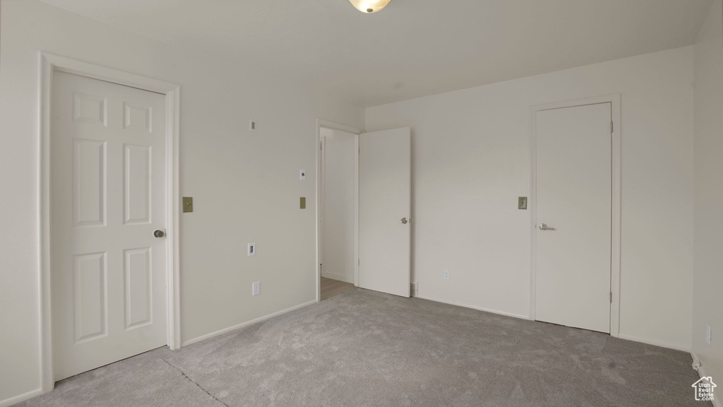 Unfurnished bedroom with carpet floors and baseboards