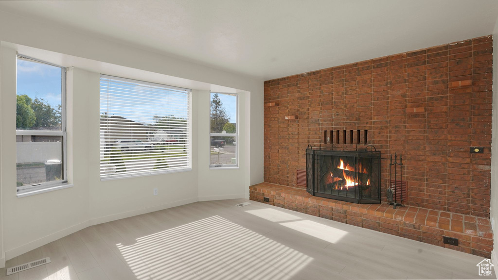Unfurnished living room with healthy amount of natural light, a fireplace, and baseboards