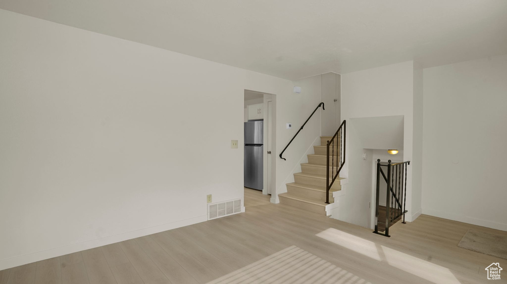 Spare room with light wood-type flooring and stairs