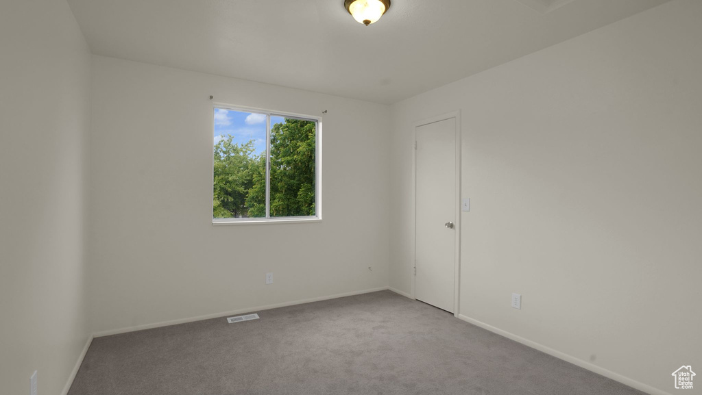 Empty room featuring carpet and baseboards