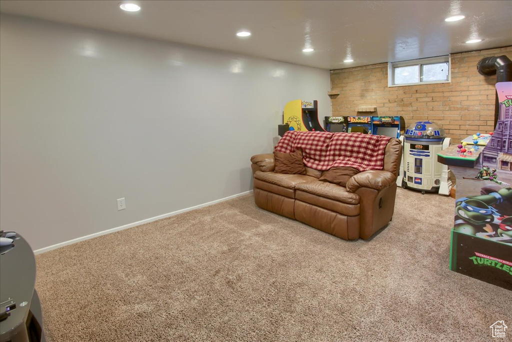 Rec room featuring carpet floors, recessed lighting, baseboards, and brick wall