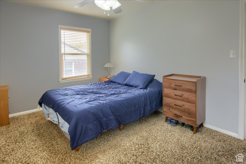 Carpeted bedroom with baseboards and a ceiling fan