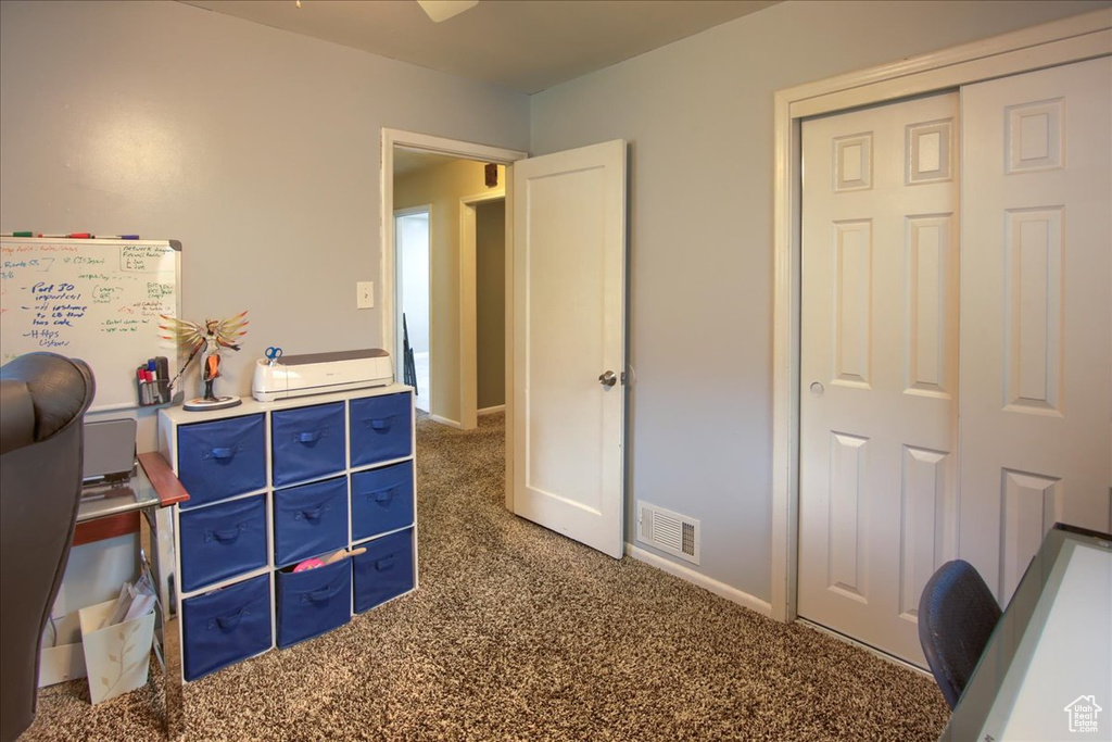 Carpeted home office featuring baseboards
