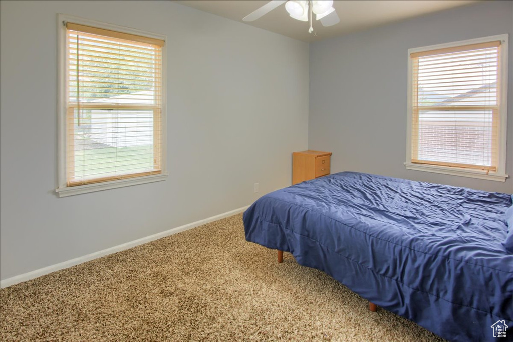 Carpeted bedroom featuring baseboards and ceiling fan