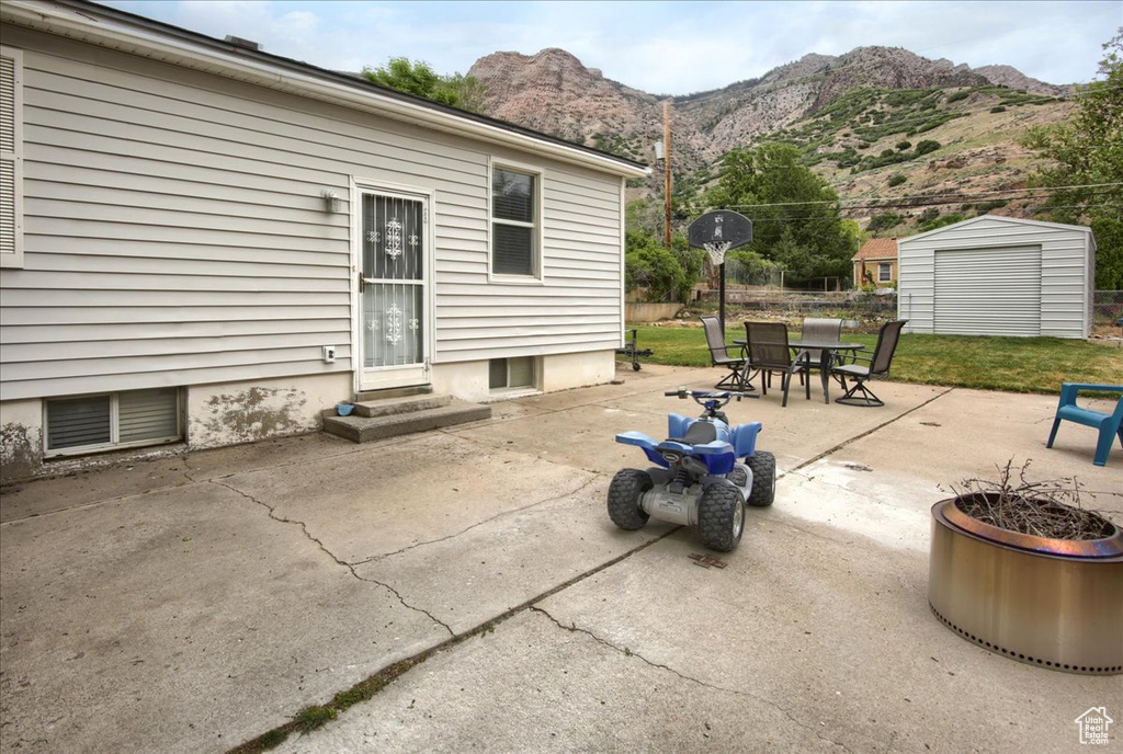 View of patio featuring entry steps, a mountain view, and outdoor dining space