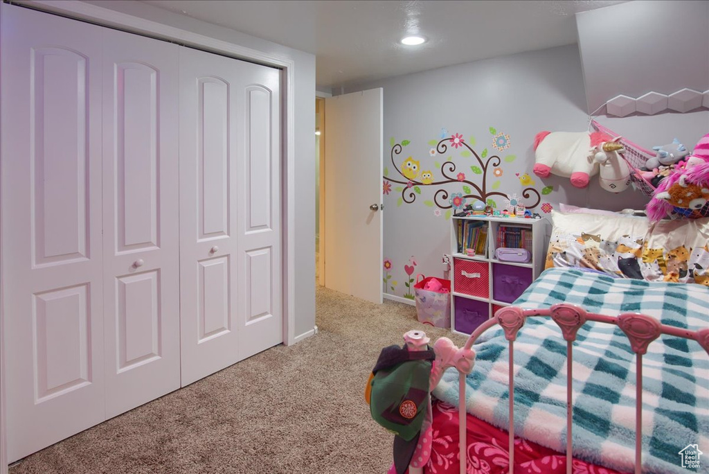 Carpeted bedroom with recessed lighting and a closet