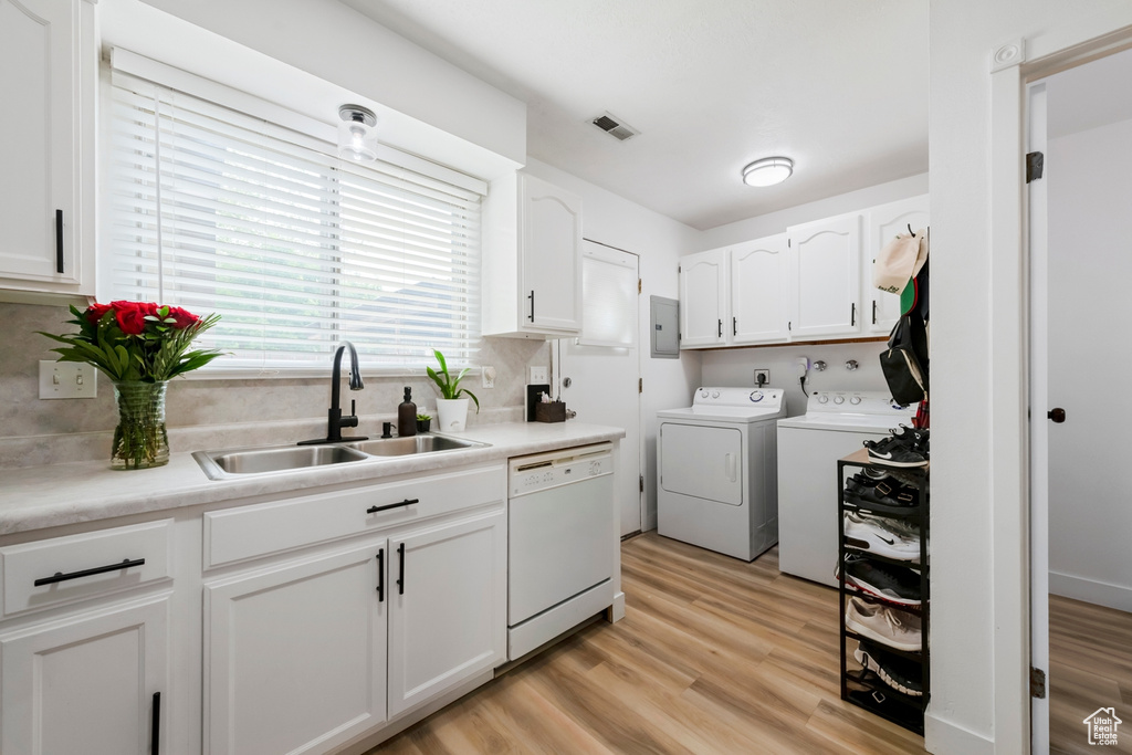 Laundry area featuring washing machine and clothes dryer, light wood-style floors, and electric panel