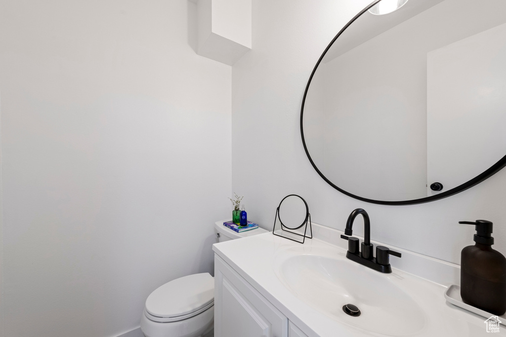 Half bathroom with vanity and toilet