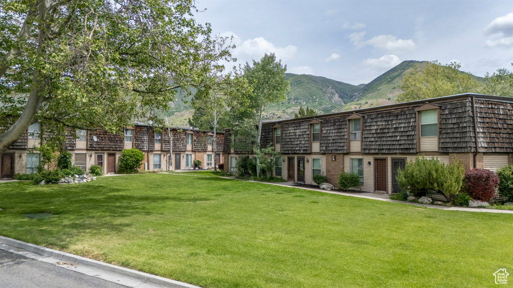 View of community featuring a mountain view and a lawn