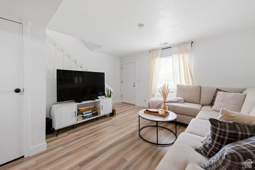 Living room featuring light wood-style floors and baseboards