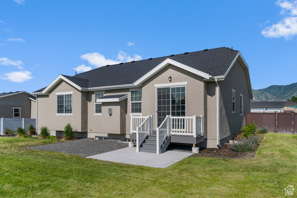 Back of property featuring a patio, stucco siding, a deck with mountain view, and a shingled roof