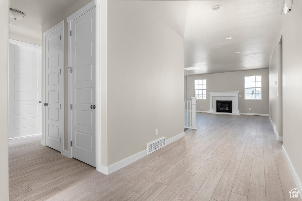 Hall featuring light wood finished floors, baseboards, and recessed lighting
