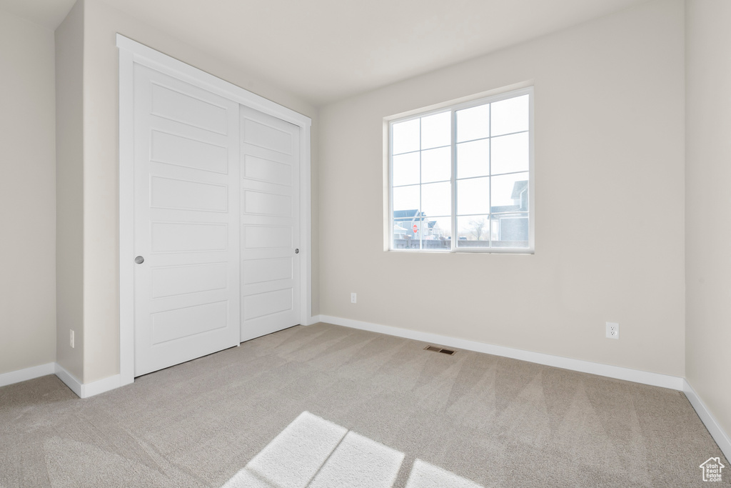Unfurnished bedroom with carpet floors, baseboards, and a closet