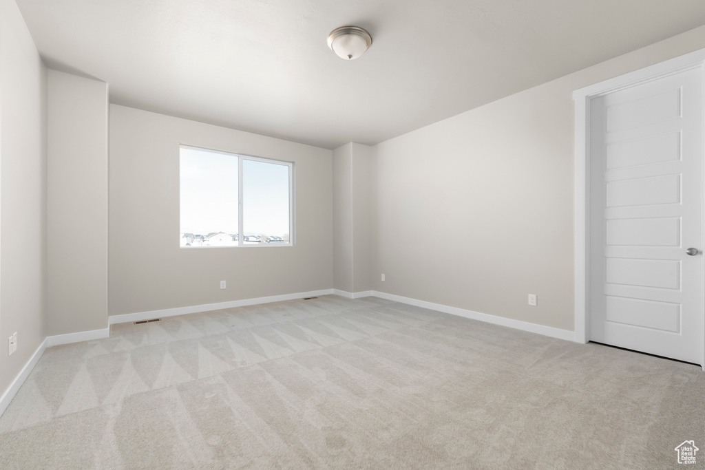 Unfurnished room with light carpet and baseboards
