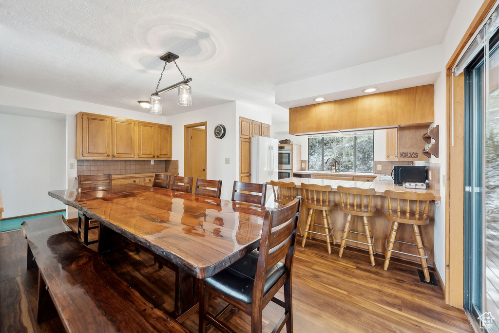 Dining area with light wood-style floors and recessed lighting