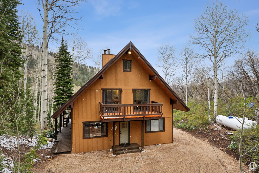 View of front of house featuring a chimney and a wooden deck
