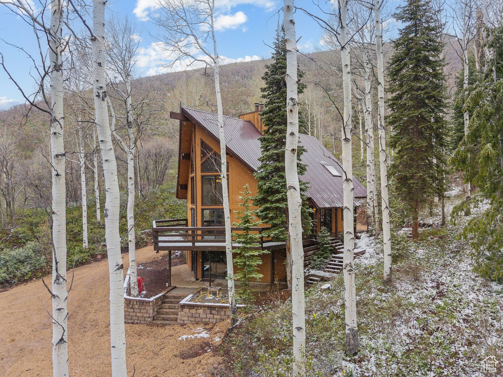 View of property exterior with a wooden deck and metal roof