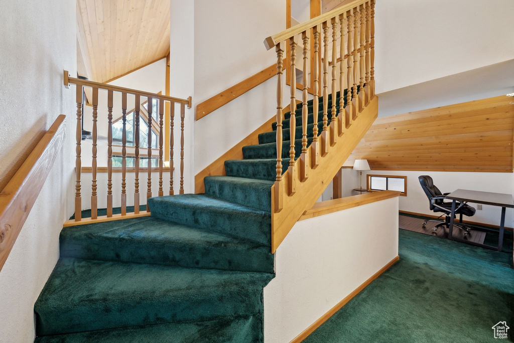 Staircase with a high ceiling and carpet floors