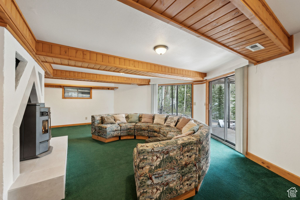 Living area with carpet, a wood stove, and baseboards