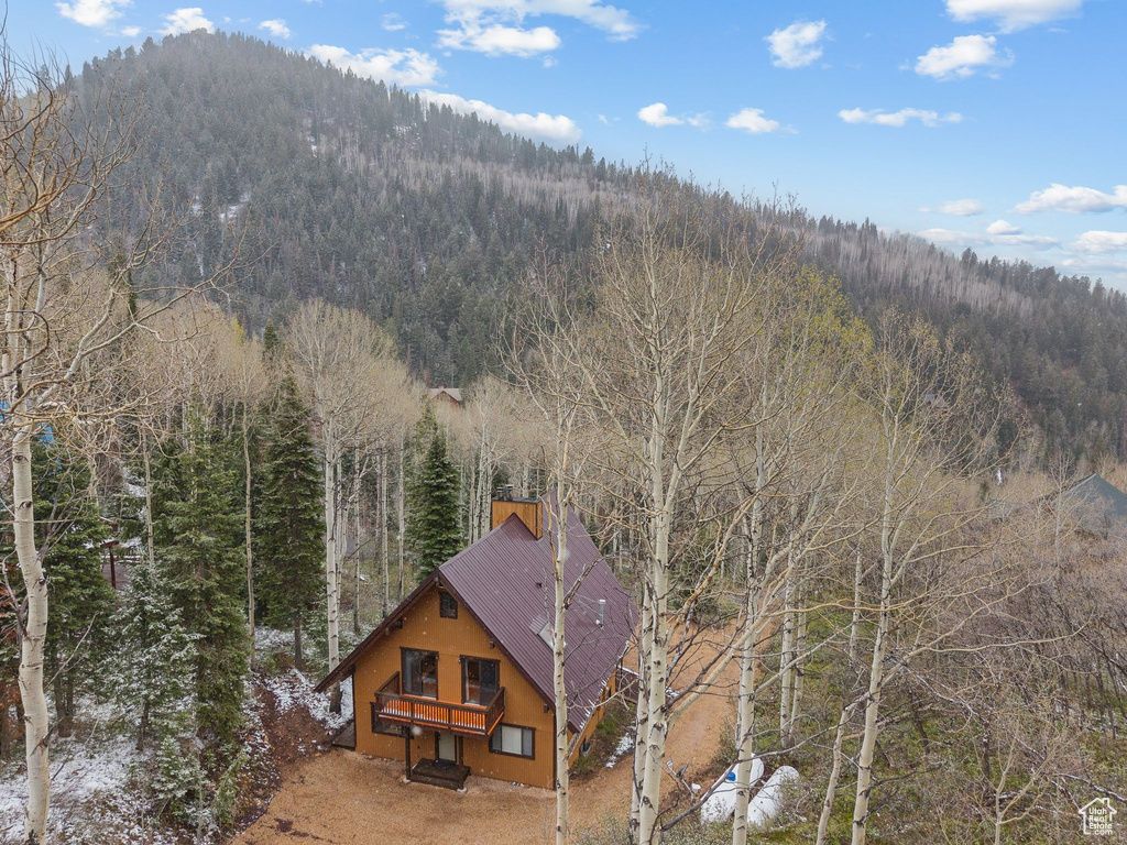 View from above of property with a heavily wooded area and a mountain backdrop