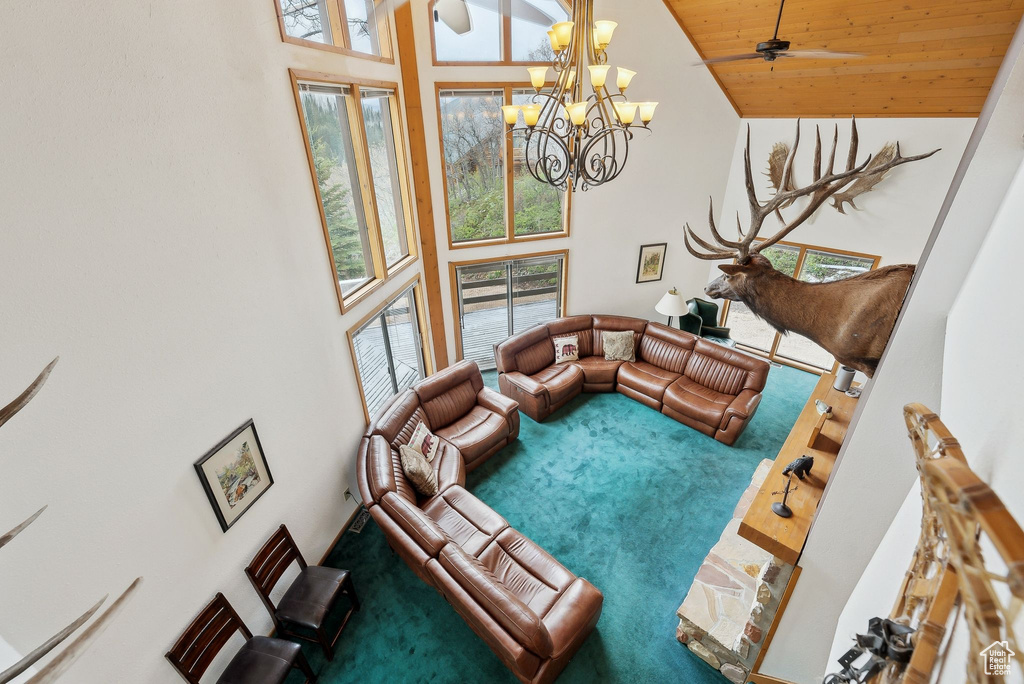 Living room featuring high vaulted ceiling, a chandelier, carpet floors, and wood ceiling