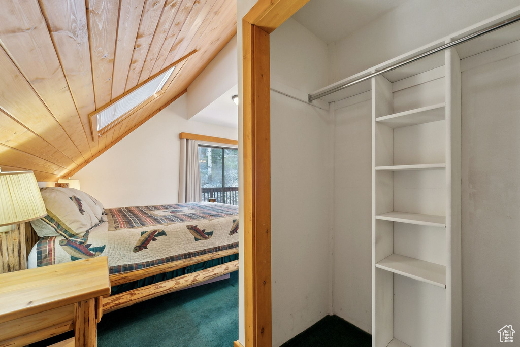 Bedroom featuring a skylight, wooden ceiling, lofted ceiling, and carpet