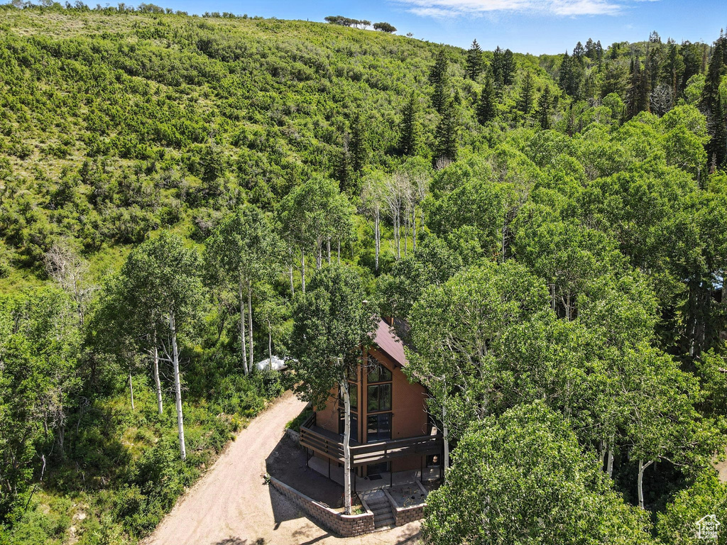 Aerial view of property and surrounding area featuring a forest